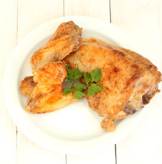 roasted chicken wings and leg with parsley in the plate
