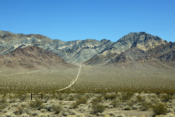 Long lonely dirt path leading to bare mountain, Nevada