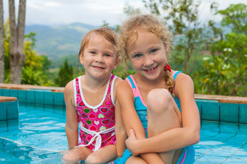 Fototapeta na wymiar two little girls playing in the pool