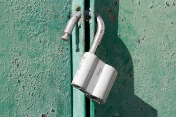 Big padlock on a green metal gate