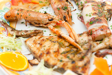 Mix grilled fish in a decorated dish.