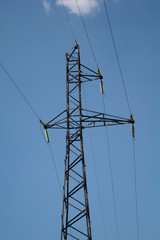 Electricity pylon against blue cloudy sky