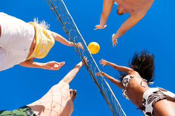 Friends playing beach volleyball