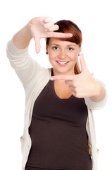 fröhliche junge frau schaut durch ihre finger