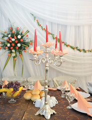 candlestick with candles and floral arrangements on wedding