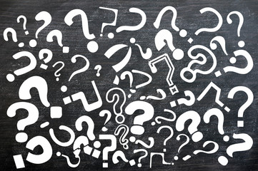 Various question marks on a blackboard