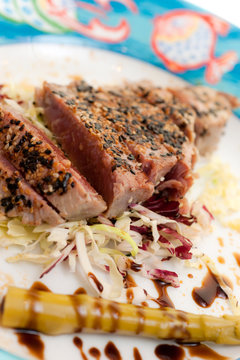 Cutted Tuna Steak with vlack and whitw sesam, asparagus and bals