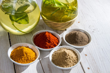 Close-up of different spices and bottles of olive oil