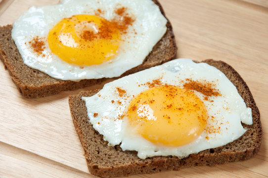 Close-up of two toasts with fried eggs, studio shot