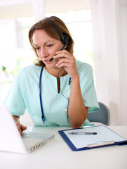 Nurse in front of laptop with headset