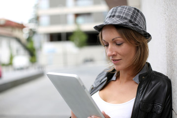 Portrait of woman using tablet in town