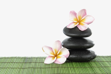 Fototapeta na wymiar spa concept with zen stones and frangipani flower on mat