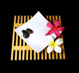 Tropical plumeria flowers on a wooden grid