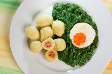 Stuffed potato dumplings with smoked meat and spinach