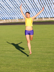 Beautiful teenage sport girl running on the grass.