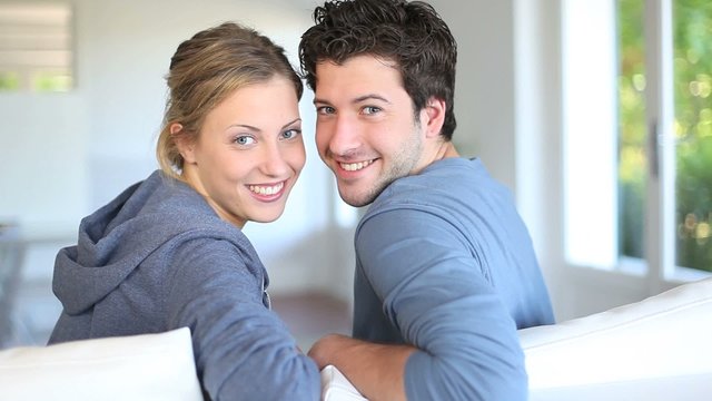 Closeup of cheerful young couple sitting in couch