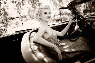 Smiling retro woman in convertible