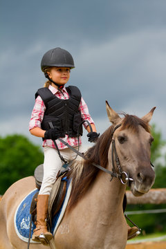 Horse riding - portrait of lovely equestrian on a horse