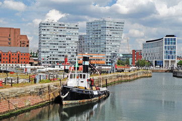 Naklejka premium A panorama of Liverpool Albert Dock with tugboat and modern buildings in the background 