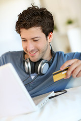 Young man buying music on internet with tablet