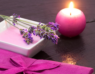 Obraz na płótnie Canvas lavender bath foam with scented candle and flowers