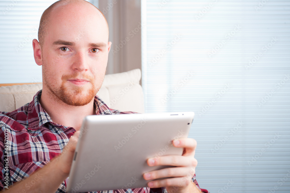 Wall mural focused man working and playing with tablet computer (lots of co