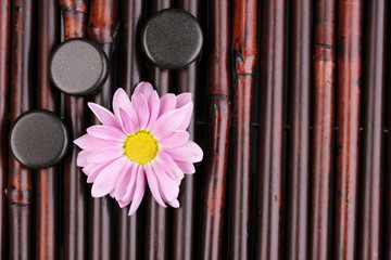 Spa stones and flower on bamboo mat
