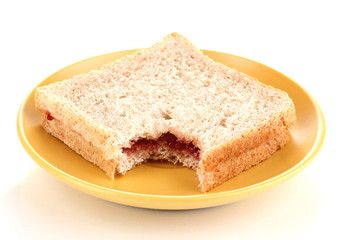 Fototapeta na wymiar Bitten sandwich with jam on plate isolated on white