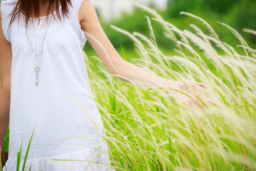 Woman's hand touching green grass
