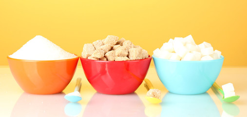 Colorful bowls with different types of sugar with colorful