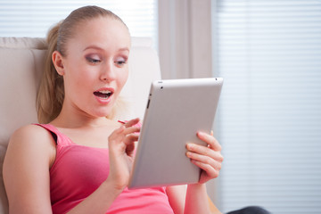 Fototapeta premium Young beautiful student using a tablet computer while relaxing