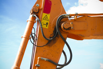 Orange tractor on blue sunrise sky, detail