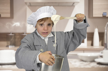 boy with chef hat and outfit making paste