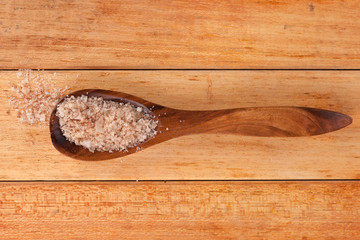 Salt flakes in wooden spoon.
