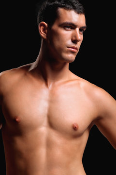 Healthy muscular young man. Isolated on black background.