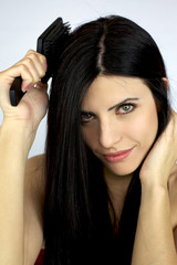 Fototapeta premium Beautiful girl brushing her long black hair
