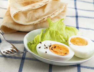 Hard boiled egg with salad on the textile background