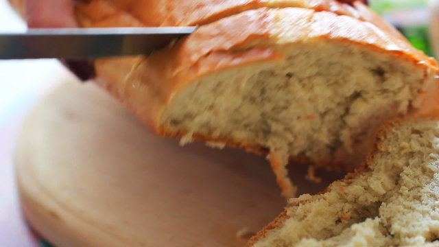 Woman slices fresh bread