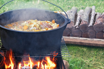 Cooking outdoors in cast iron cauldron 