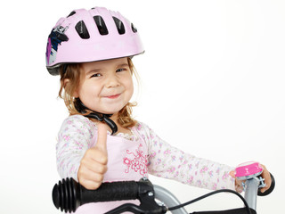 Cute girl with bicycle helmet shows thumb up