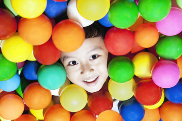 Fototapeta na wymiar Szczęśliwy Asian chłopiec z kolorowymi kulkami
