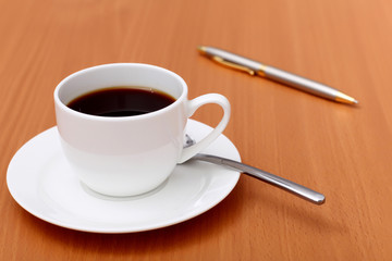 Black coffee in a cup and pen