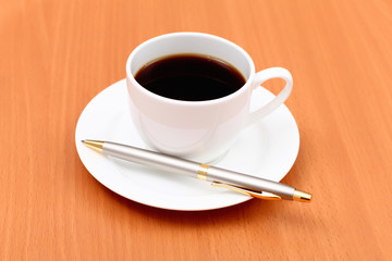 Black coffee in a cup and pen