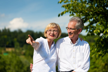 Glückliches älteres Paar macht einen Spaziergang im Sommer