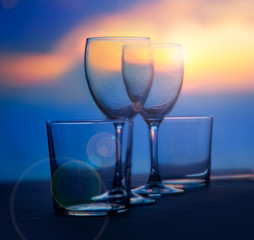 Dish of cups and crystal glasses on sea sunset