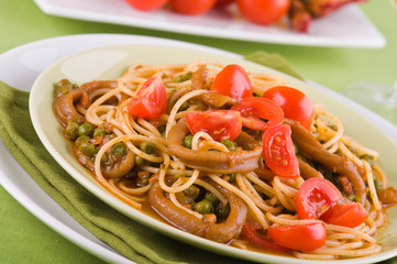 Spaghetti with squids, peas and cherry tomatoes.