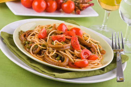 Spaghetti with squids, peas and cherry tomatoes.