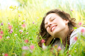 Naklejka na ściany i meble Piękne Młoda Kobieta leżącego w łąki Kwiatów. Ciesz Przyroda