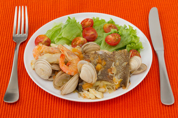 fish stew with salad on the white plate