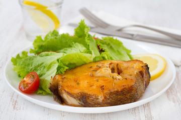 fish with salad and lemon on the white plate